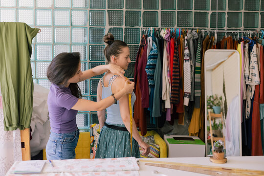 seamstress taking measurements of a client