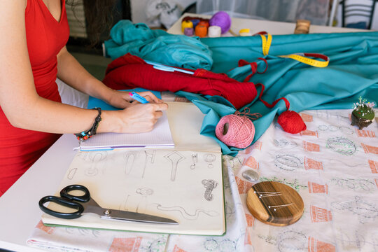 seamstress hands writing in a notepad