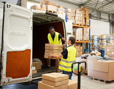 Two Warehouse  Workers Unloading Delivery Van