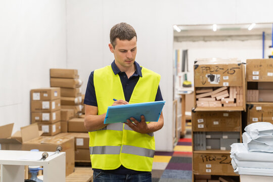 Man Making Notes At Warehouse