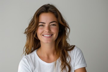 Fototapeta premium Smiling brunette woman in white t-shirt on white background.