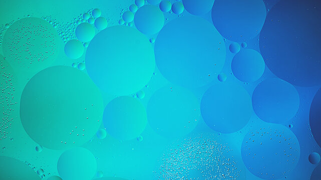 Abstract blue and green colorful background with oil on water surface. Oil drops in water abstract psychedelic, abstract image.