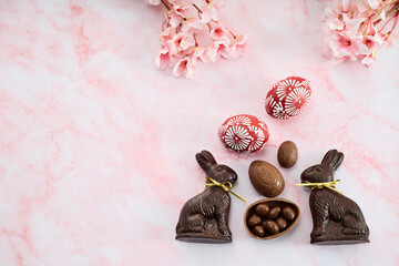 Chocolate easter eggs and bunnies on pink marble background