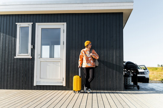 female traveler in yellow hat at eco hotel, ready for outdoor fun