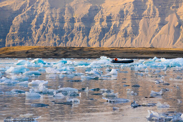 kayaking people among floating glacier in tranquil glacier lagoon 