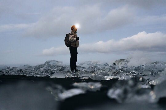 Solo traveler with backpack enjoy ice under cloudy sky in Iceland