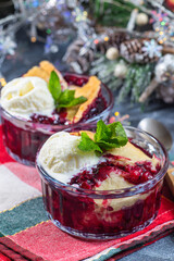 Delicious Berry cobbler in glass ramekin with ice cream, Christmas decoration, vertical
