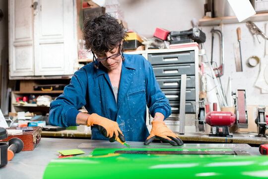 Skilled senior worker cutting vinyl stickers at workshop
