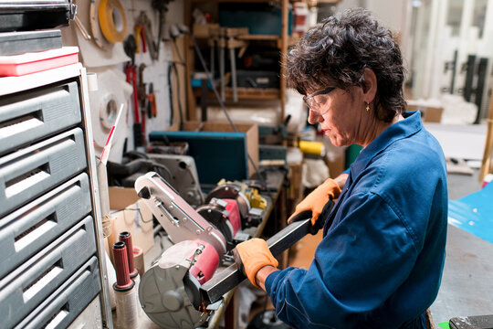 Mature woman working with metal at workshop