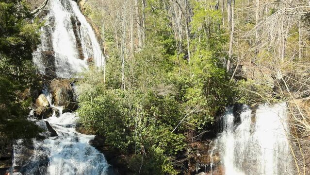 tilt footage of the rushing water, rocks and waterfall at Anna Ruby Falls with lush green trees and plants in Helen Georgia USA