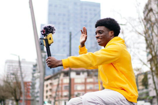 Joyful young african influencer creating content in the city.