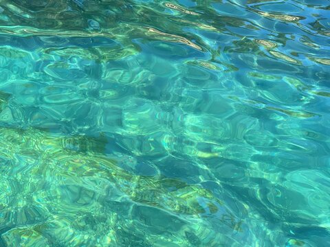 Aqua sea water blue turquoise clear pebbles underwater.