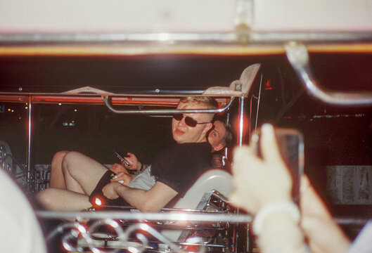 UGC film image of 2 young men in the back of a Tuk Tuk in Bangkok