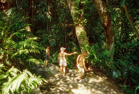 A family exploring a waterfall and river gorge in Northern Thailand.