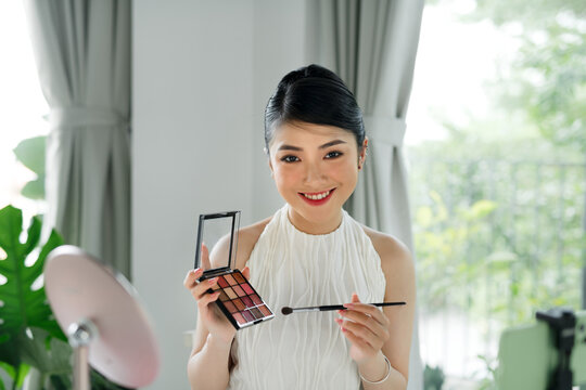 Happy woman beauty blogger recording makeup tutorial video stream