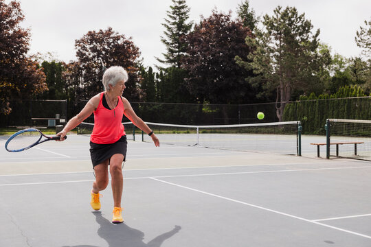 Woman about to hit the ball in a sunny game of tennis.