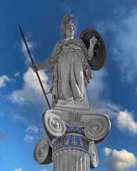 Athena statue, the ancient Greek goddess of wisdom and science, on a Corinthian style column with partly cloudy sky background. Athens, Greece. Filtered image.