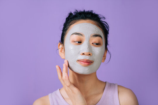 Young asian woman refreshing facial mask