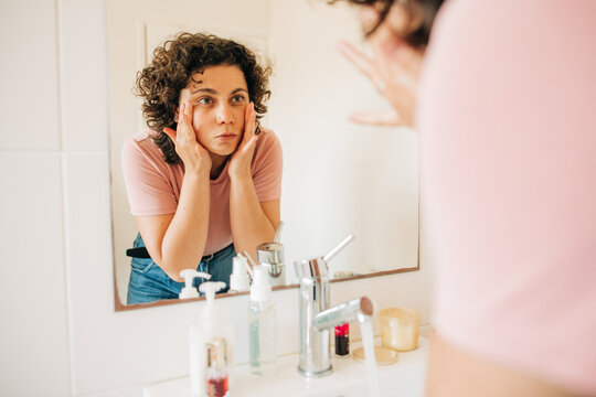 Woman washing her face in bathroom