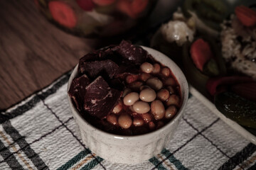 traditional turkish white beans stew with bacon, boiled rice and salted marinade vegetables, cucumbers, green tomatoes, carrot, pepper, served ready to eat kuru fasulye