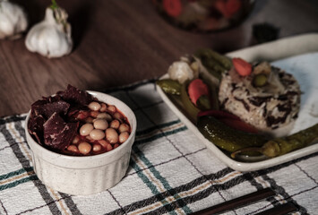 traditional turkish white beans stew with bacon, boiled rice and salted marinade vegetables, cucumbers, green tomatoes, carrot, pepper, served ready to eat kuru fasulye