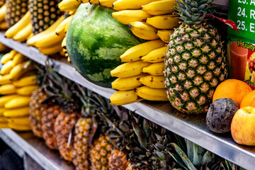 Fruit stand selling pineapples, watermelons, bananas in the streets of Manhattan, in the Big Apple of New York City in the United States of America.
