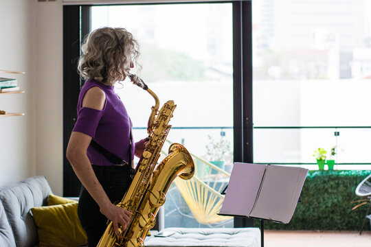 Woman reading sheet music and playing the saxo