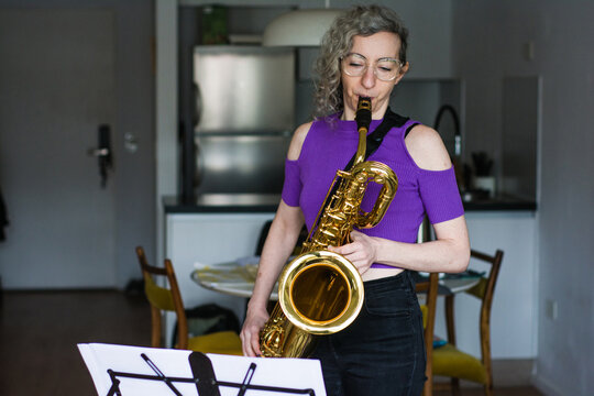 Woman playing the saxophone at home