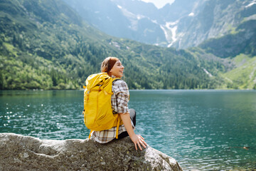 Active woman enjoys the beautiful scenery of the majestic mountains and lake. Travel, adventure....