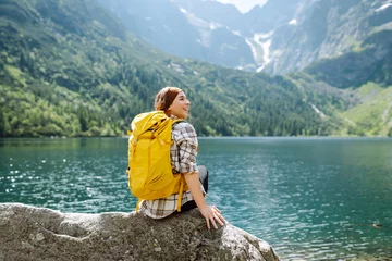 Papier Peint photo autocollant Tatras Active woman enjoys the beautiful scenery of the majestic mountains and lake. Travel, adventure. Concept of an active lifestyle.