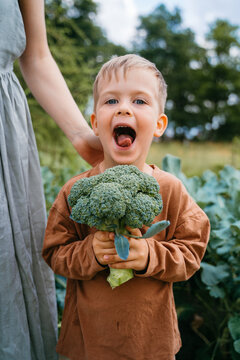 Portrait of a child standing next to his mother in the garden