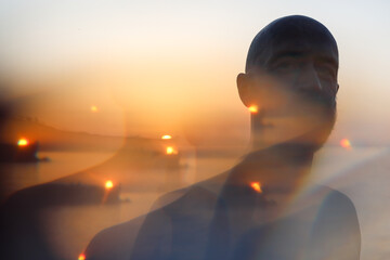 Portrait of a man in front of the sunset with a kaleidoscope effect 