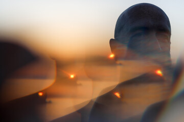 Portrait of a man in front of the sunset with a kaleidoscope effect 
