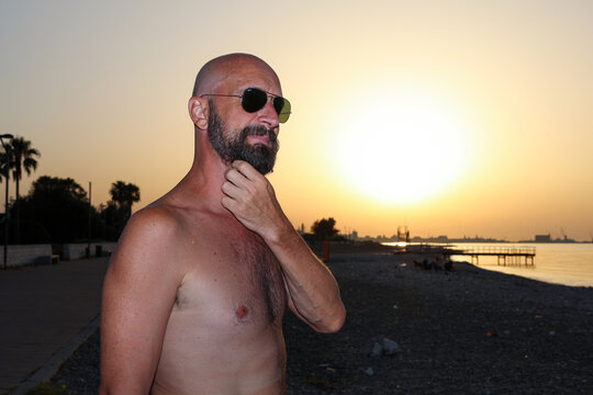 stylish bald man scratching and grooming his beard