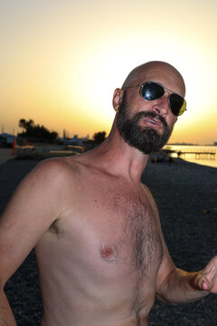 Talkative man making cool dance moves at the beach and enjoy sunset