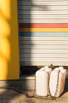 White plastic jerrycan in front of iron gate