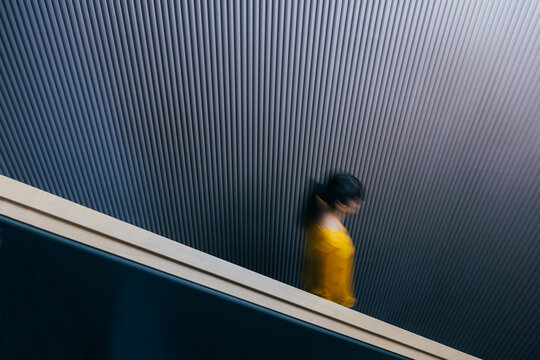 A blurred woman going down the stairs 