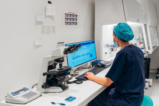 Female medical personnel working on computer in laboratory.