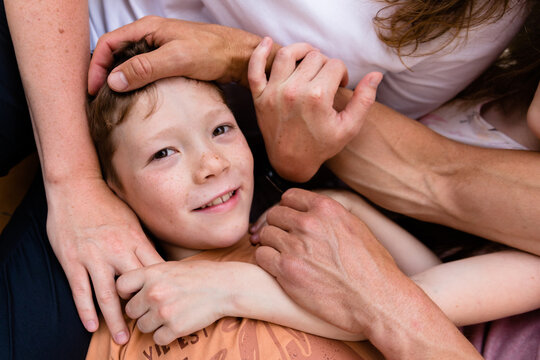 Little boy among the hands of his family