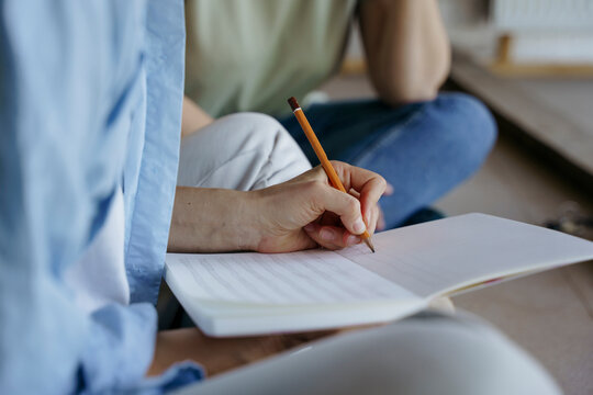 Hands draw a plan in a notebook