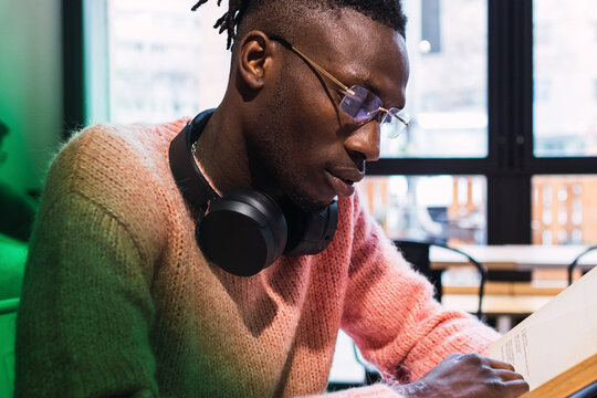 Black man reading book in cafe