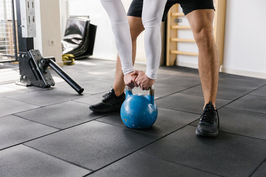 Close up image of male hands holding kettlebell in the gym