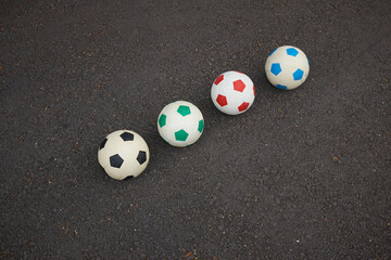 Minimal photo of colourful footballs with asphalt background