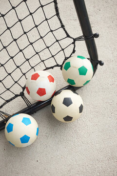 Minimal photo of footballs on goal net with concrete background