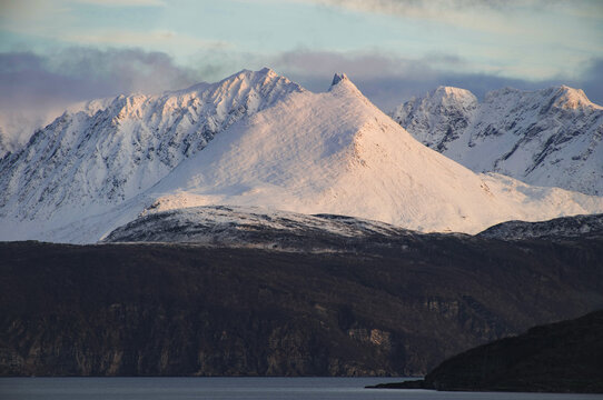 Dramatic light and clouds over mountain peaks around Tromso 