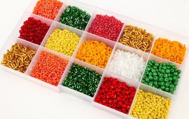 Plastic beads of different colors in separate cells of the container