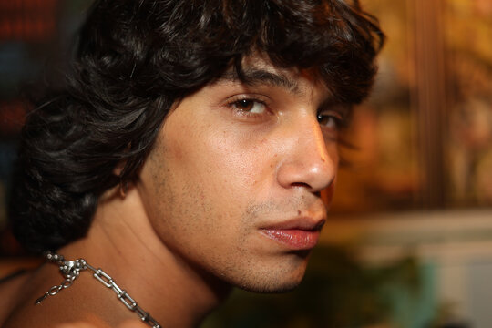 Profile portrait of young man with a serious face looking at camera