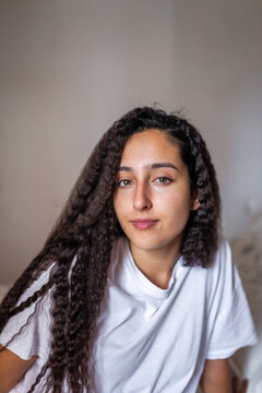 portrait of teen girl with curly hair in her bedroom