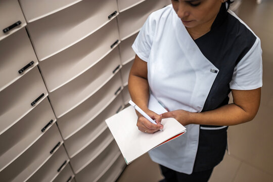 Pharmacist woman placing orders in the warehouse in a pharmacy