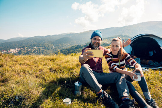 Couple taking a selfie on a hiking and camping adventure in the mountains